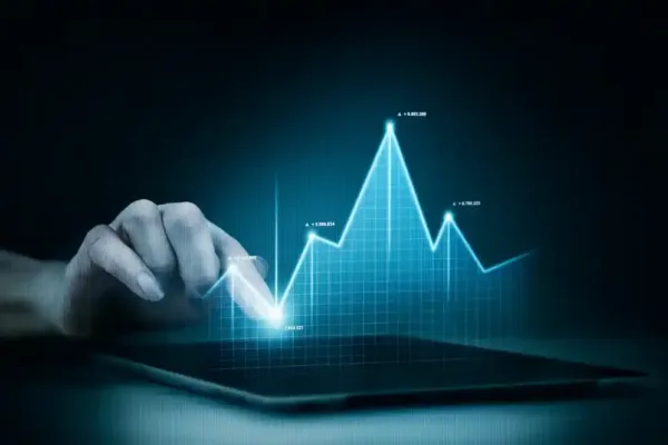 A imagem mostra uma mão apontando para um gráfico de linhas em uma tela digital, que representa a evolução de indicadores financeiros. A linha flutua, mostrando picos e vales que podem simbolizar a performance de um negócio, como vendas ou lucro. Essa imagem é típica para ilustrar o conceito de análise de dados financeiros, que é essencial para aumentar a eficiência do e-commerce. Através da monitoração e análise desses indicadores, os negócios podem tomar decisões informadas para otimizar suas operações e melhorar o desempenho financeiro.